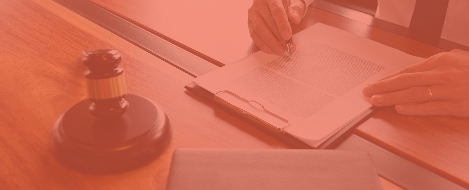 a judge's desk with a gavel and a legal document held by a seated person