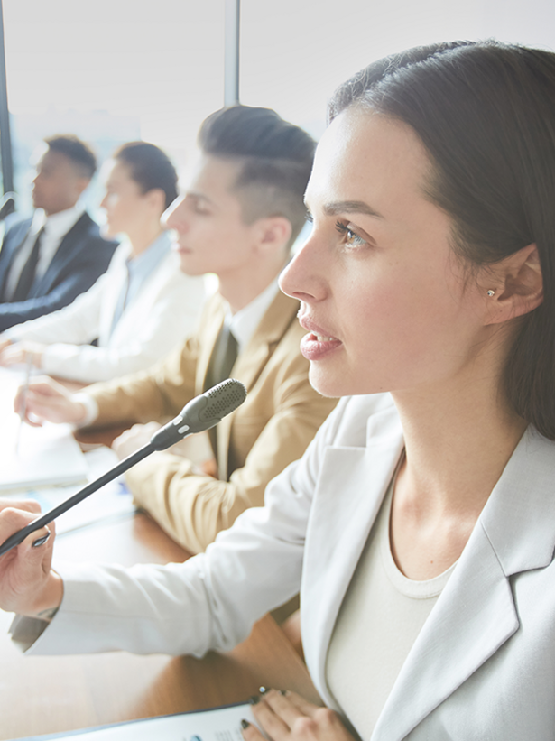 a woman speaking into a microphone at a professional event
